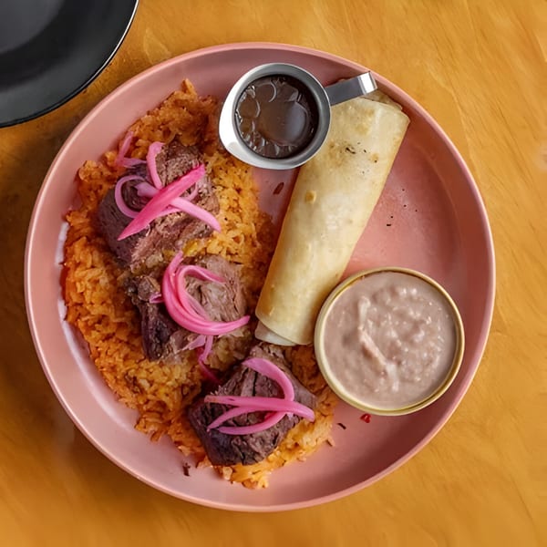 Jefe's Cantina + Cocina's Mexican dish with rice, beef, pickled onions, a burrito, and sauces.